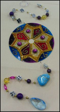 a necklace with beads and other items on the table next to it is an ornament that looks like a flower