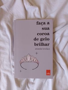 a book is laying on a bed with white sheets and pillows in the background that reads, faca sua coroa de gelo brilhar