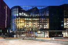 a large building with many windows and lights on it's sides at night time