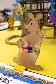 a paper kangaroo holding a basket of candy