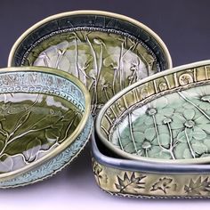 three bowls with designs on them sitting next to each other in front of a white background