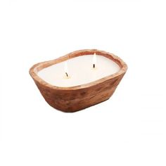 a wooden bowl filled with two candles