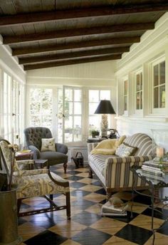 a living room filled with furniture and lots of windows