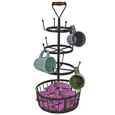 a metal rack with cups and saucers in it on top of purple napkins