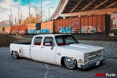 a white truck parked in front of a train track