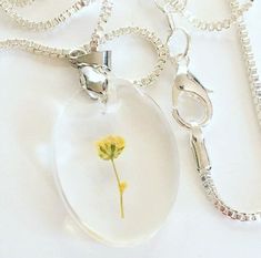 This beautiful Botanical necklace is handmade out of flowers and resin. It is a simple piece of jewelry that is perfect for any nature lover! This pendant is placed on a 20 inch sterling silver box chain. Rectangle necklace, simple and elegant, all occasions, floral wear Minimalist Sterling Silver Necklace With Pressed Flowers, Minimalist Flower Jewelry With Pressed Flowers, Delicate Sterling Silver Necklace With Pressed Flowers, Dainty Sterling Silver Necklace With Pressed Flowers, Clear Flower-shaped Birth Flower Jewelry, Clear Flower Shaped Birth Flower Jewelry, Delicate Sterling Silver Jewelry With Pressed Flowers, Delicate Oval Pressed Flower Jewelry, Silver Flower Necklace With Pressed Flowers