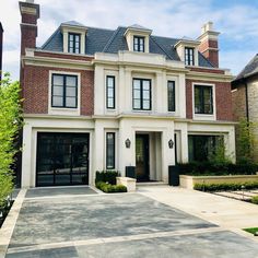 a large white house with lots of windows on the front and side of it's doors