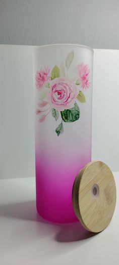 a pink and white vase sitting next to a wooden container with flowers painted on it