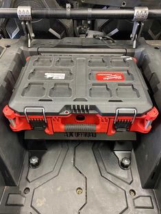 the back end of a red four wheeler with its cargo compartment open and wheels out