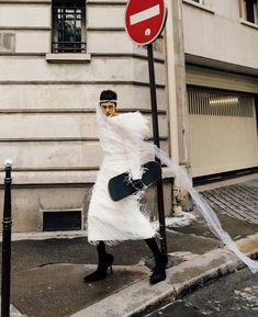 a person dressed as a ghost holding a snowboard next to a no entry sign