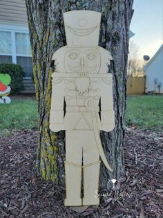 a wooden cutout of a man standing next to a tree