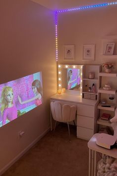 a room with a desk, chair and television in it that is turned on to show barbie the movie