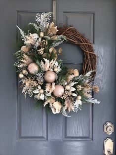 a wreath on the front door is decorated with white flowers and greenery for christmas