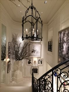 a chandelier hanging from the ceiling in a room with pictures on the wall