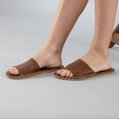 Introducing the Lion Barefoot Slide Sandals the perfect addition to your summer wardrobe. Handmade in Turkey with 100% natural materials, these sandals are crafted with a natural leather upper and a water buffalo leather sole, ensuring maximum comfort and breathability for your feet. With a wider toe box, your toes have enough room to spread and relax, promoting a more natural gait and posture. The "zero-drop" non-elevated heel helps maintain proper posture as well. Available in sizes ranging fr Leather Sole Slip-on Mules For Vacation, Beach Flip Flops With Leather Footbed, Summer Huarache Sandals With Leather Sole For Vacation, Vacation Slip-on Sandals With Leather Footbed, Summer Vacation Huarache Sandals With Leather Sole, Vacation Leather Footbed Slip-on Sandals, Leather Slippers With Cushioned Footbed For Vacation, Brown Slides With Cork-bed Midsoles And Single Toe Strap, Comfortable Open Toe Sandals With Woven Sole