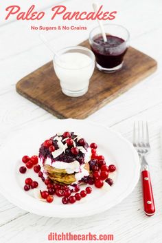 a white plate topped with food next to a glass of milk and fork on top of a wooden cutting board