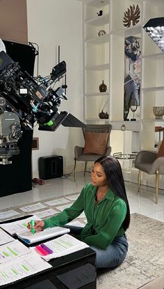 a woman sitting on the floor in front of a projector and looking at it