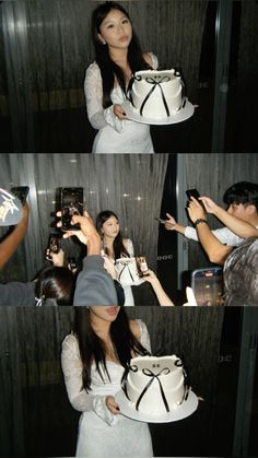 a woman holding a cake in front of her face and taking pictures with her cell phone