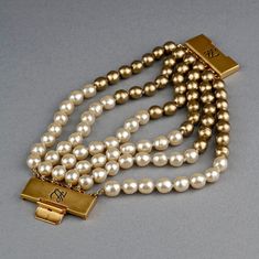 Features: - 100% Authentic KARL LAGERFELD. - 6 Strands of cream and gold baroque glass pearls. - Signed KL twice on the closure. - Push and snap closure. - Gold tone hardware. - It has substantial weight. - Excellent vintage condition. Measurements: Height: 2.36 inches (6 cm) Wearable Length: 8.26 inches (21 cm) **This bracelet will be shipped via Priority Shipping with tracking number. Please convo me for any queries and additional photos. Thank you for visiting. Other Fees that buyers need to Elegant Beige Bracelets For Formal Occasions, Elegant Beige Bracelet For Formal Occasions, Elegant Beige Bracelets, Elegant Beige Bracelets For Parties, Kl Logo, Vintage Karl Lagerfeld, Pearl Cuff Bracelet, Figural Jewelry, Gold Baroque