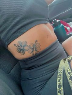 a woman with a flower tattoo on her lower back and the bottom half of her stomach