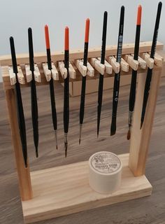 a wooden display with many different types of knives on it's sides and an orange tip in the middle