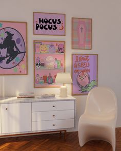 a white chair sitting next to a dresser in a room with pictures on the wall