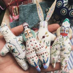 three small stuffed animals sitting on top of each other in someone's hand,