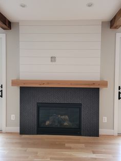 an empty living room with a fireplace and white walls