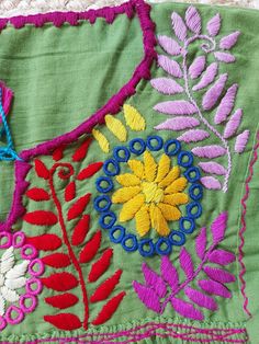 an embroidered piece of cloth with flowers and leaves on it