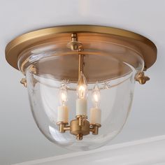 three candles are lit in the center of a semi flush - flush ceiling light fixture