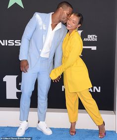 a man and woman posing on the blue carpet