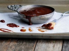 a metal bowl filled with sauce sitting on top of a tray