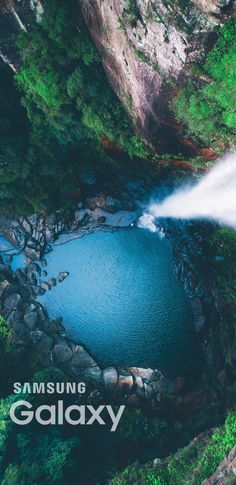 an aerial view of a blue lake surrounded by trees and rocks with the words samsung galaxy above it