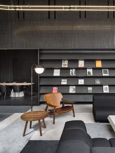 a living room filled with furniture and lots of bookshelves on the wall behind it