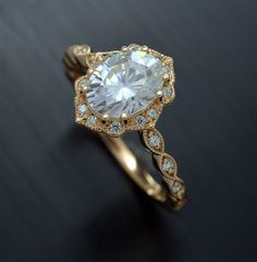 an engagement ring with a large white diamond in the center and small blue diamonds around it