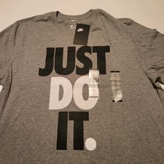 Nike Men's Just Do It Graphic T-Shirt Grey Color Grey With Black And White Lettering Just Do It Add Some Statement-Making Style To Your Sporty Essentials With The Iconic Slogan Boldly Printed At The Front Of This Just Do It T-Shirt From Nike. Crewneck Imported Printed Slogan At Front Nike Cotton T-shirt In Athletic Heather, Nike Gray Tops With Letter Print, Nike Gray T-shirt With Logo Print, Gray Crew Neck Shirt With Logo Print, Nike T-shirt In Athletic Heather With Logo Print, Nike Gray Tops With Logo Print, Nike Gray Top With Logo Print, Nike Athletic Heather T-shirt With Logo, Nike Gray Cotton Tops