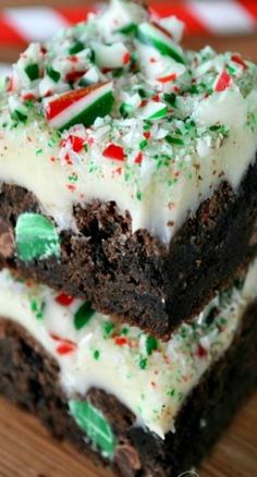 two brownies with white frosting and candy canes are stacked on top of each other