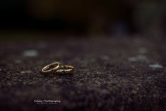 two wedding rings sitting on the ground