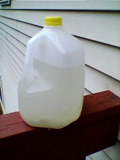 a plastic jug sitting on top of a wooden bench