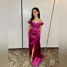 a woman in a purple dress posing for the camera