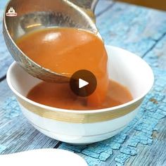 a bowl filled with orange liquid being poured into it