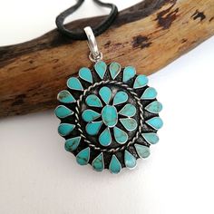 "This stunning Squash Blossom pendant was handcrafted in Mexico. Each teardrop bezel is inlaid with turquoise coloured enamel enhanced with tiny brown flecks. Surrounding the centre blossom is a woven wire accent. Complete with an 18\" inch black cord ready to wear! The pendant is approximately 2\" inches long. This piece is silver plated. The pattern of the enamel may vary very slightly, they are all individually hand crafted. If you've got any questions don't hesitate to ask me. This pendant c Adjustable Southwestern Turquoise Pendant Necklace, Turquoise Concho Necklace As Gift, Bohemian Turquoise Teardrop Pendant Necklace, Bohemian Blue Turquoise Necklace With Concho, Bohemian Blue Turquoise Concho Necklace, Blue Bohemian Concho Necklace, Bohemian Blue Concho Necklace, Handmade Southwestern Teardrop Pendant Necklace, Handmade Southwestern Necklace With Teardrop Pendant