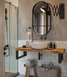 a white sink sitting under a mirror in a bathroom next to a walk in shower