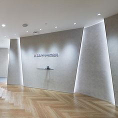 an empty room with wooden floors and white walls, in the middle of a museum