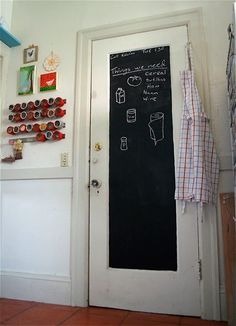 a chalkboard is hanging on the wall next to a door