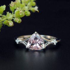 "1.3 Carat trillion cut pink Morganite, magnificently set on a V shank with 2 princess cut diamonds on either side. Crafted in 14K Solid White Gold this minimalist yet unique beauty is definitely a stunner and a keeper! * Center Stone : Pink Morganite * Stone Shape : Trillion (7 mm) * Stone Wt: 1.32 ct * Diamond : Princess Cut * Diamond Wt. : 0.05 Cts * Diamond Color-Clarity Grade : H-I, Vs Si * Gold - 14kt, White gold If you like this ring, please press \"Pin it\" button on the right of your sc Morganite Diamond Engagement Ring, Diamond Rings With Price, Pink Morganite Engagement Ring, Diamond Ring Princess Cut, Oval Diamond Engagement, Stackable Wedding Bands, Morganite Diamond, Pink Morganite, Morganite Engagement