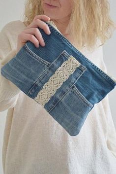 a woman is holding an old pair of jeans