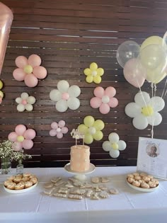 a table topped with lots of balloons and desserts