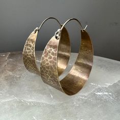 These sweet, wide brass hoops make great "every day" earrings. Hammered and oxidized, sterling ear wire fits into hole in back of hoop to close. Small - around 3/4" diameter Medium - 1 1/2" diameter Large - a little over 2" diameter Everyday Metal Hoop Earrings With Oxidized Finish, Hammered Copper Hoop Jewelry, Small Copper Hoop Jewelry, Hammered, Everyday Hand Forged Bronze Earrings, Artisan Oxidized Hoop Earrings, Artisan Copper Hoop Earrings Nickel Free, Artisan Hoop Earrings With Oxidized Finish, Bronze Brass Hoop Earrings With Ear Wire, Artisan Nickel Free Copper Hoop Earrings