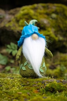 a small green gnome with white hair and a blue hat